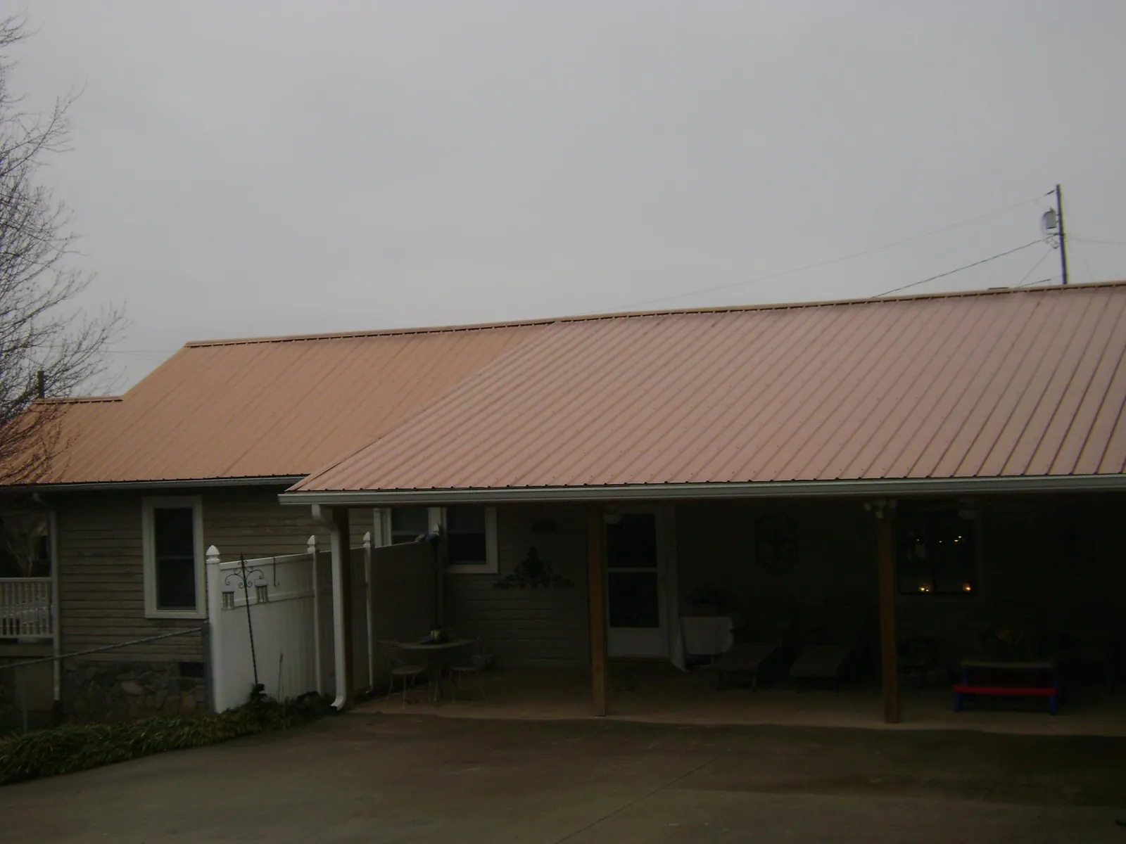 Copper toned metal roof over a wide covered patio in Montvale
